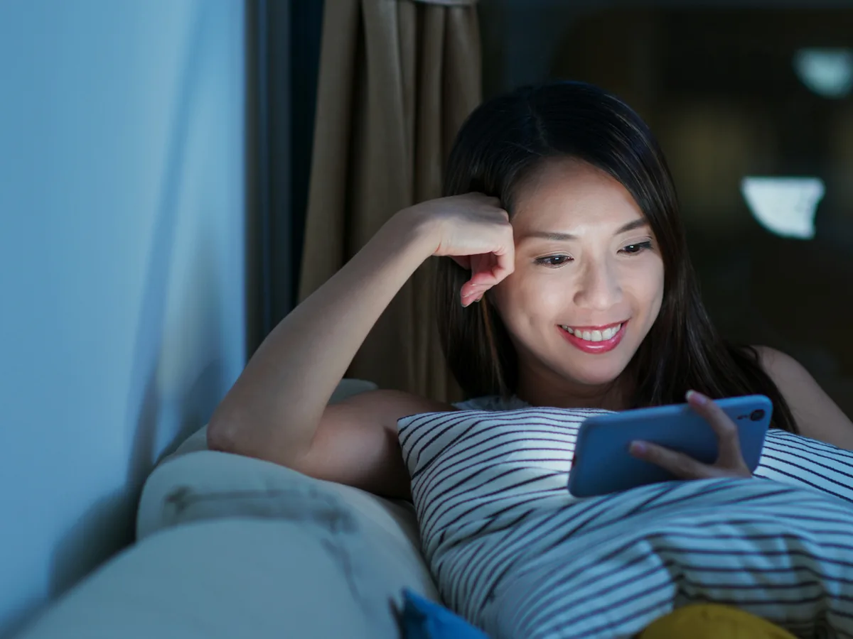 A reader watching a video on her phone at night
